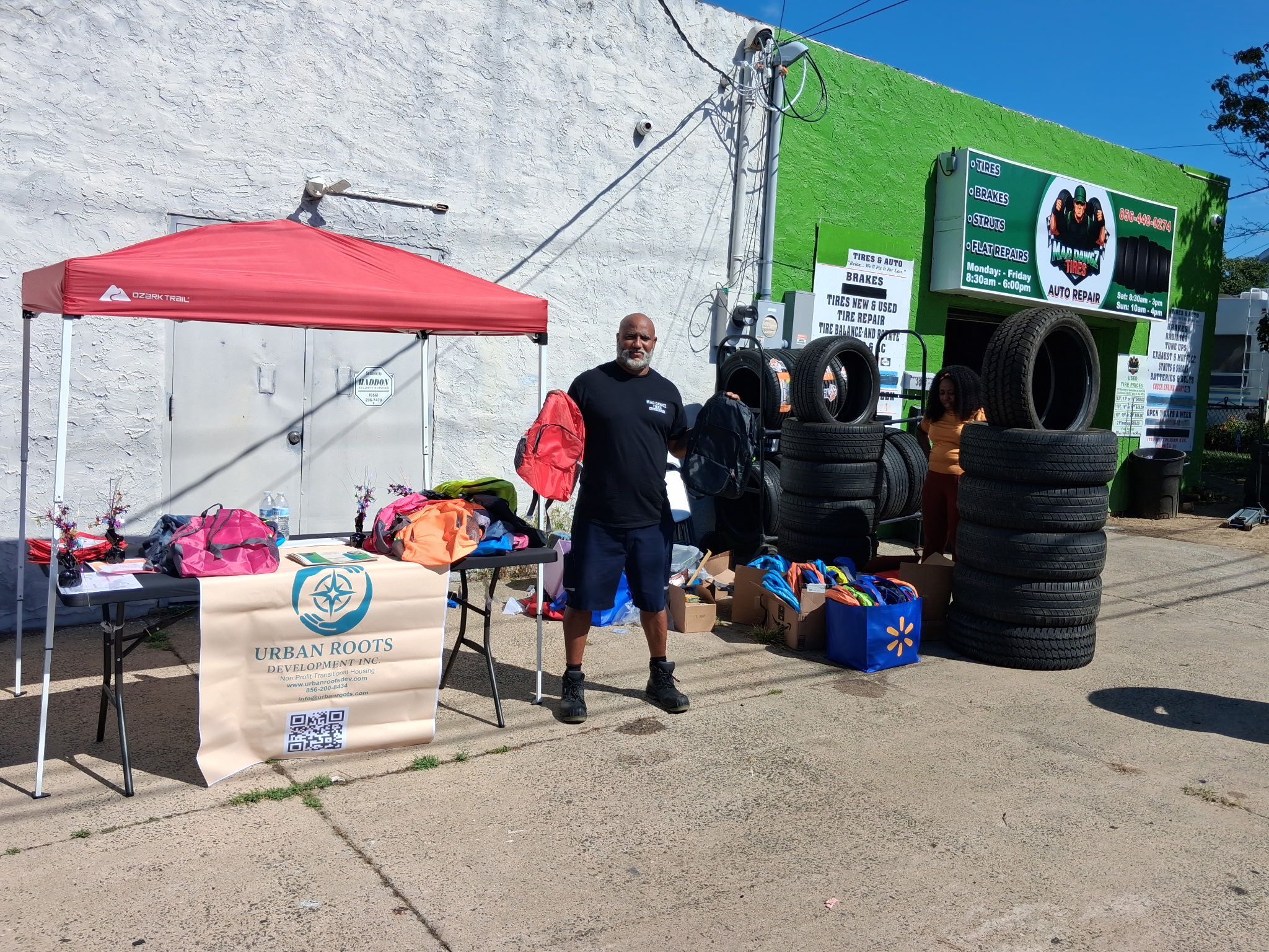 Mad Dawgz owner outside the shop handing out free backpacks and tires at the Community Awareness & Safety Day